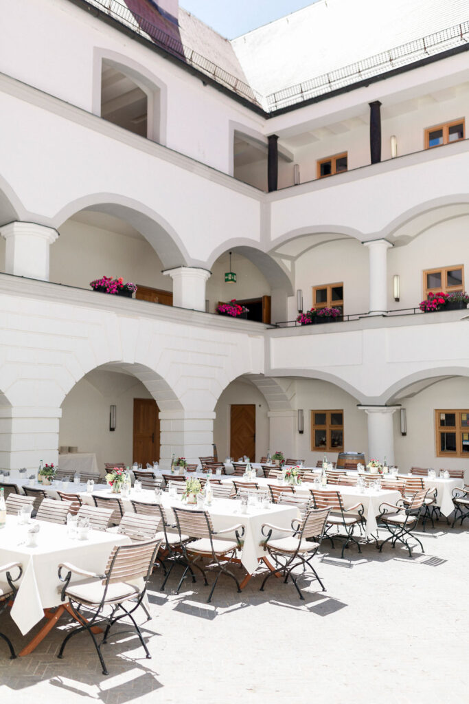 Innenhof eines Schlosses mit Tischen und Stühlen